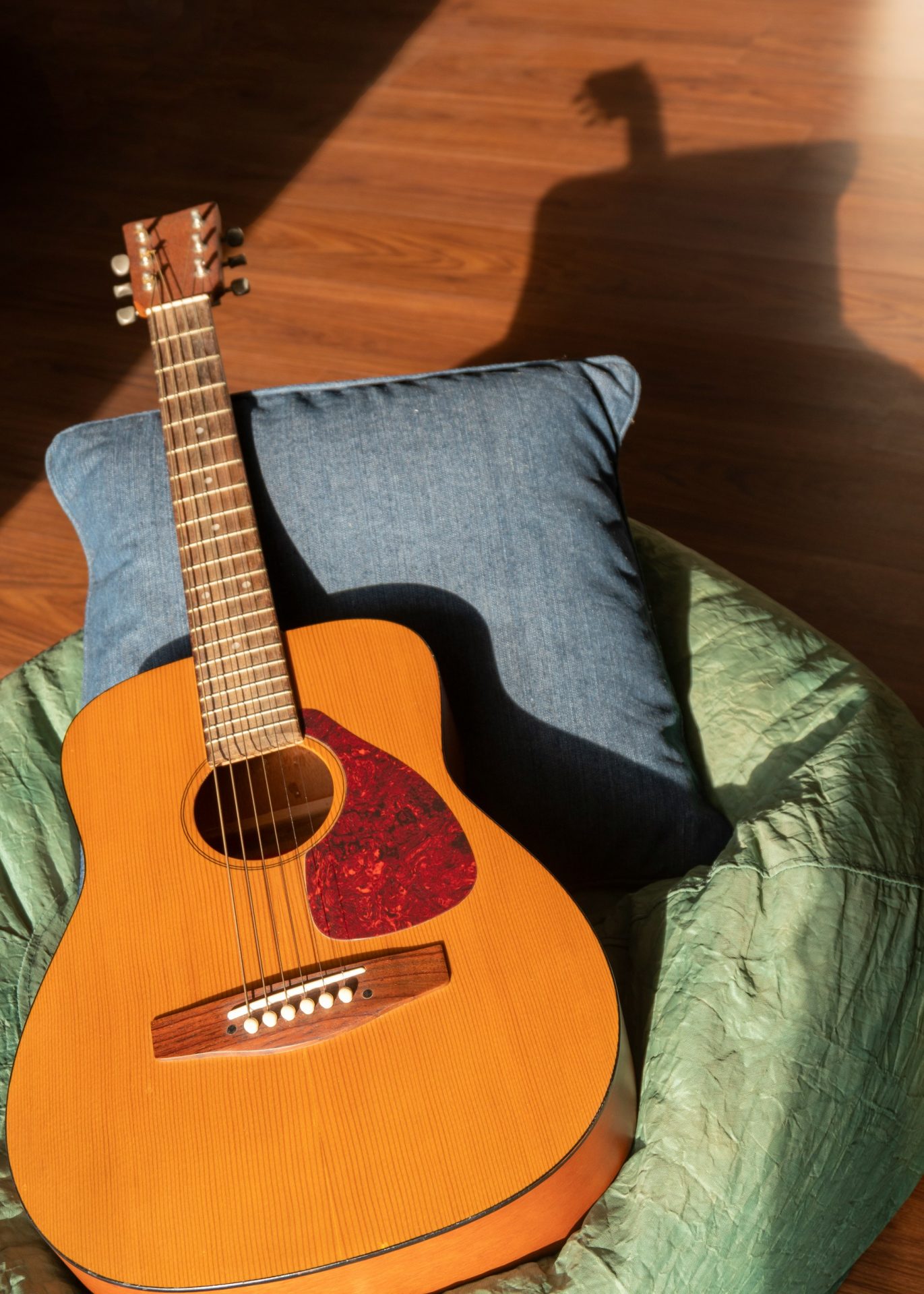 Acoustic guitar resting in a chair in warm sunlight